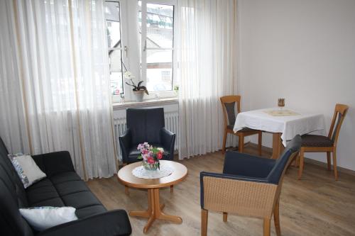 a living room with a couch and a table at Pension / Ferienwohnung Allebrodt in Lennestadt