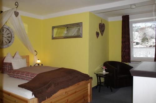 a bedroom with a bed and a clock on the wall at Hildfelder Stübchen in Winterberg