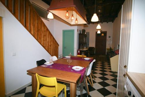 a kitchen with a table, chairs and a refrigerator at Casa dos Batalim in Monchique