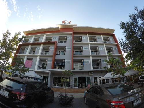 a large building with cars parked in front of it at R2 Apartment Service in Nakhon Ratchasima