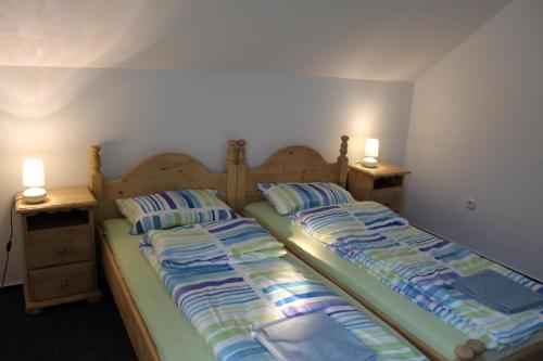 サトゥ・マーレにあるAqua Apartmentsのベッド2台(両側にランプ2つ付)が備わるベッドルーム1室