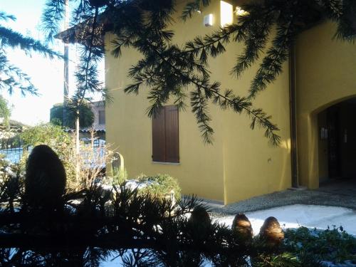 a yellow building with a door and some trees at B&B Casa Dolce Casa in Candelo
