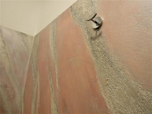 a shower with a door knob on a wall at Hotel Etnea Royal Suites in Catania