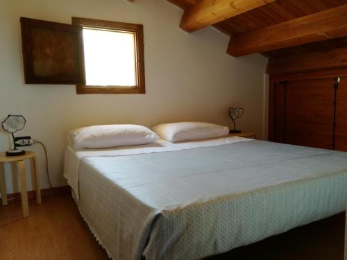 una camera da letto con un grande letto e una finestra di Casetta Rosina a Scopello