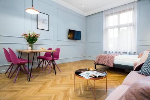 un soggiorno con letto, tavolo e sedie di P&J Luxury Apartments a Cracovia