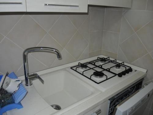 a kitchen with a stove and a sink at Sea View Eden in Porto Cervo