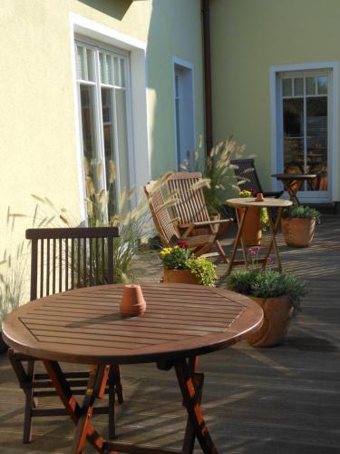 a wooden table and chairs on a patio at Landhaus Hammoor Stieper Gastronomie GmbH in Hammoor