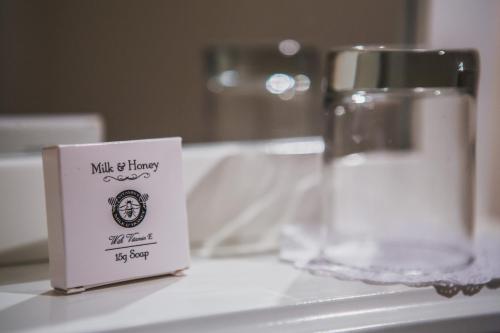 a small sign on a counter next to a glass at Burton Lodge Guest House & Spa in Brandesburton