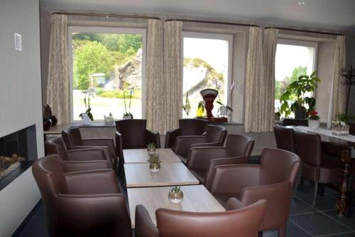 a dining room with tables and chairs and windows at au-magasin in Vielsalm