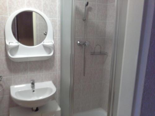 a bathroom with a sink and a shower with a mirror at Almet, apartmánove štúdio 205 in Donovaly