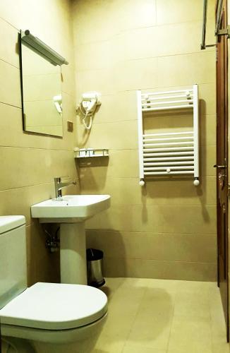a bathroom with a toilet and a sink at Cozy Hotel Kazbegi in Stepantsminda