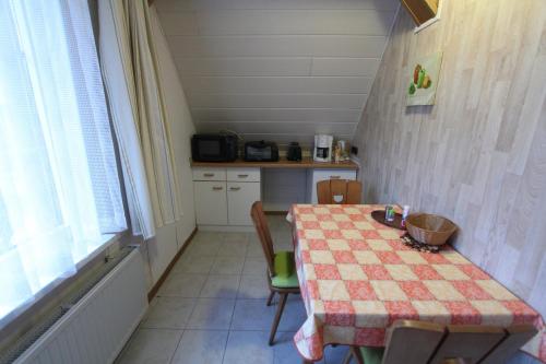 a kitchen with a table with a checkered table cloth at Gästehaus Mea Vota in Braunlage