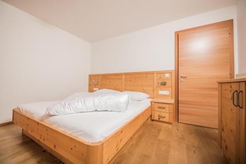a bedroom with a bed and a wooden cabinet at Pichlerhof in Valle Di Casies