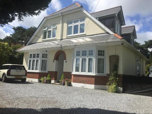 a house with a car parked in front of it at Heatherdene House in Wimborne Minster