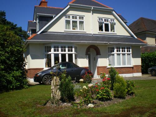 a house with a car parked in front of it at Heatherdene House in Wimborne Minster