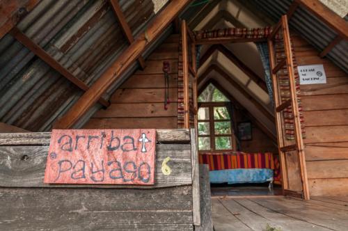 an entrance to a wooden cabin with a sign on it at La Iguana Perdida in Santa Cruz La Laguna