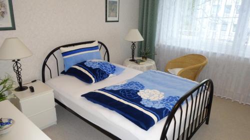 1 dormitorio con 1 cama con sábanas azules y blancas en ABT Private Rooms Hannover Exhibition Ground (room agency), en Hannover