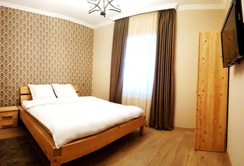 um quarto com uma cama e uma janela em Cozy Hotel Kazbegi em Stepantsminda