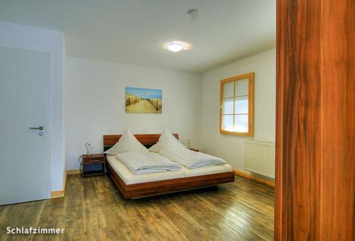 ein Schlafzimmer mit einem Bett in der Mitte eines Zimmers in der Unterkunft Ferienwohnung Warnemünde in Warnemünde