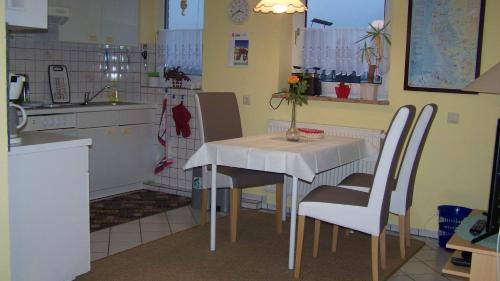 uma cozinha com uma mesa e cadeiras numa cozinha em Goden Wind 20 em Westerdeichstrich