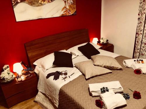 - une chambre avec 2 lits, des serviettes blanches et des murs rouges dans l'établissement Corso 126 Guest House Salerno, à Salerne