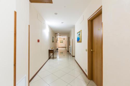 a hallway with white walls and a door at La Piana Hotel in Tito