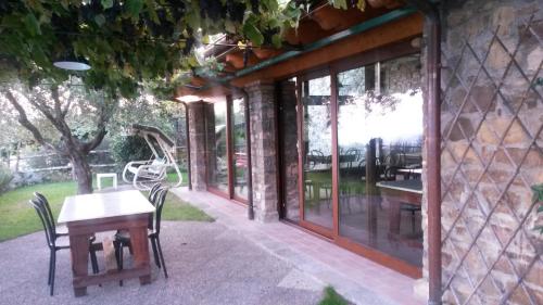 a patio with a table and chairs and windows at Giunasco in Bagnone