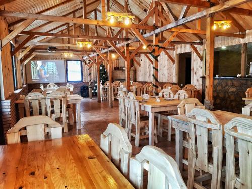 una sala da pranzo con tavoli e sedie in legno di Cozy Hotel Kazbegi a Kazbegi