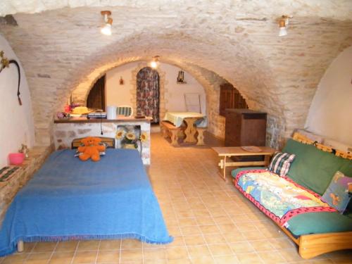 Orgnac-lʼAvenにあるLa Bergerie de Marieのベッドルーム(青いベッド1台、ソファ付)