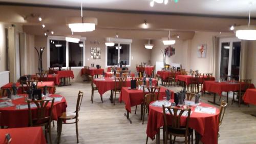 a dining room with red tables and chairs at Auberge des Etangs in Roussent