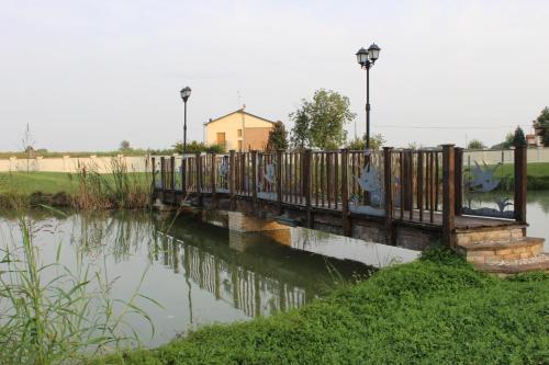 a wooden bridge over a body of water at Villa Dello Spino in Concordia sulla Secchia