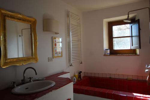 LubrianoにあるCasa con vista mozzafiato su Civita di Bagnoregioのバスルーム(シンク、赤いバスタブ付)