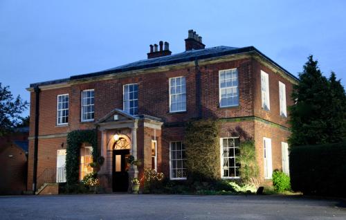 a large brick building with a front entrance at Dovecliff Hall Hotel in Burton upon Trent