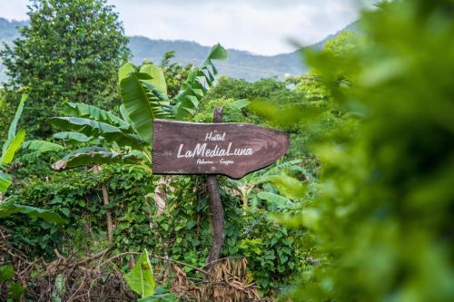 a sign in the middle of a forest at Hostal La Media Luna Palomino in Palomino