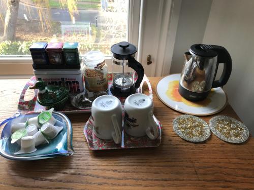 a table with a coffee maker and a tea kettle at Holmewood Homestay in London