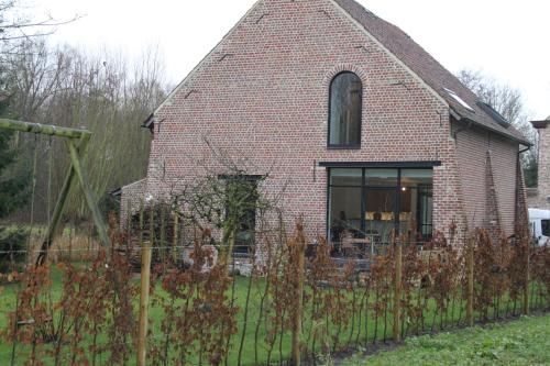 a brick house with a fence in front of it at Logies Tommenmolen in Grimbergen