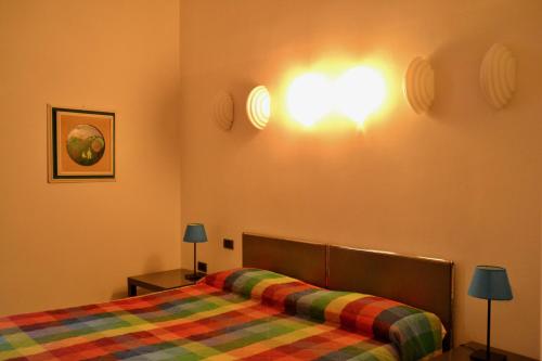 a bedroom with a bed and two lights on the wall at Hotel Italia in Foligno