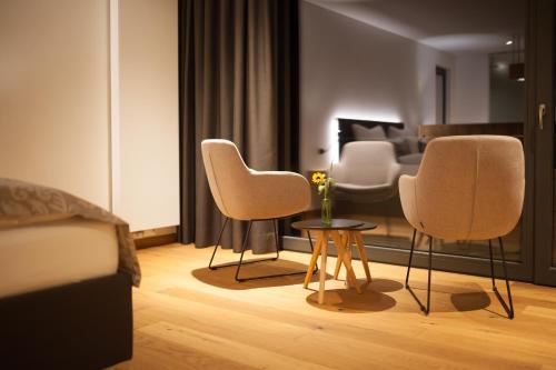 a living room with three chairs and a table at Weinvilla Vollmayer in Hilzingen