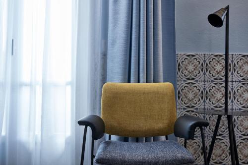 a yellow chair sitting in front of a window at Angelina Boutique Escape in Perdhika