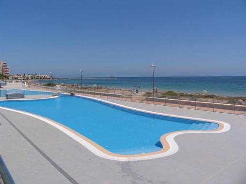 a large swimming pool next to the beach at Meandyou Marazul Lamanga in La Manga del Mar Menor