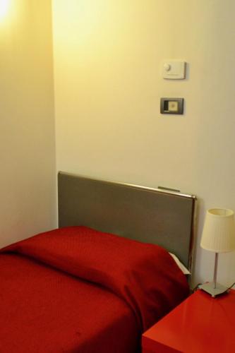 a bedroom with a red bed with a red blanket at Hotel Italia in Foligno