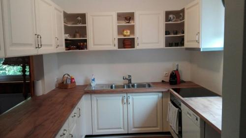 a kitchen with white cabinets and a sink at Ferienhaus Roman in Hinterstoder
