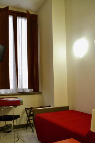 a bedroom with a red bed and a window at Hotel Italia in Foligno