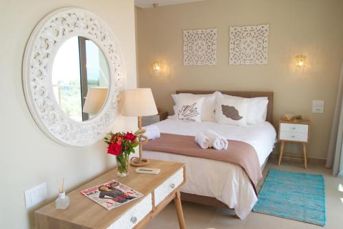 - une chambre avec un lit avec un miroir et une table dans l'établissement Villa Ion Pangea Villas, à Trapezaki