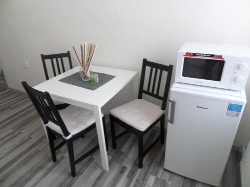 a small white table with two chairs and a microwave at Apartmány Trutnov Promenáda in Trutnov