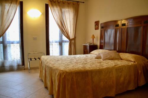 a bedroom with a large bed in a room with windows at Hotel Italia in Foligno