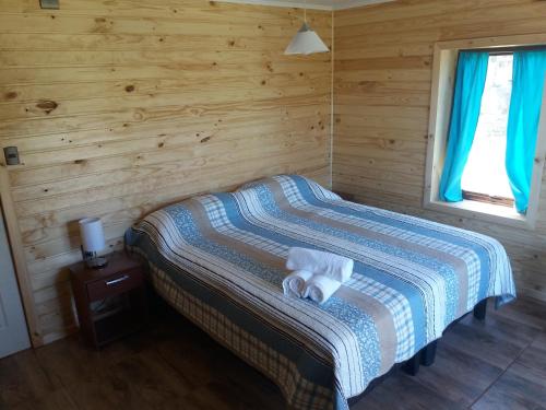a bedroom with a bed with two towels on it at Cabañas Rincon del Sur in Cochrane