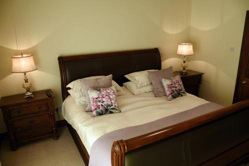 a bedroom with a bed with pillows and two lamps at Lios Daire in Killarney