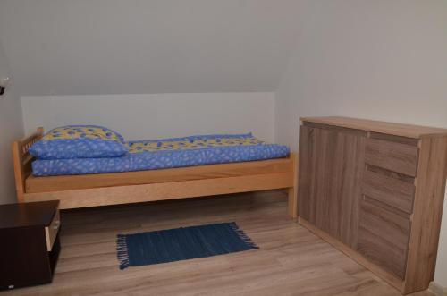 レスコにあるAgroturystyka Domek u Barbaryのベッドルーム1室(ベッド1台付)、木製キャビネットが備わります。