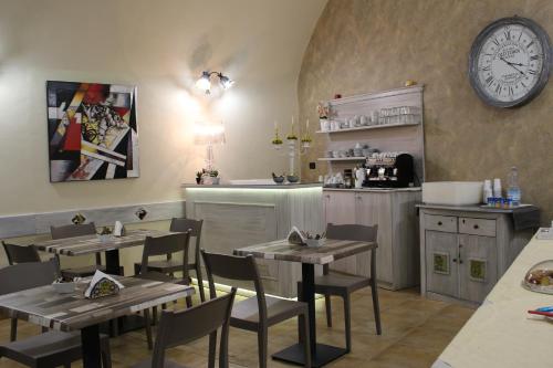 a dining room with tables and a clock on the wall at Bed & Breakfasts Conte Perollo in Sciacca